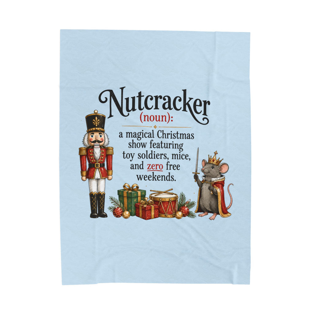 A light blue kitchen towel featuring a humorous Christmas definition of 'Nutcracker' with an illustration of a nutcracker soldier and a crowned mouse.