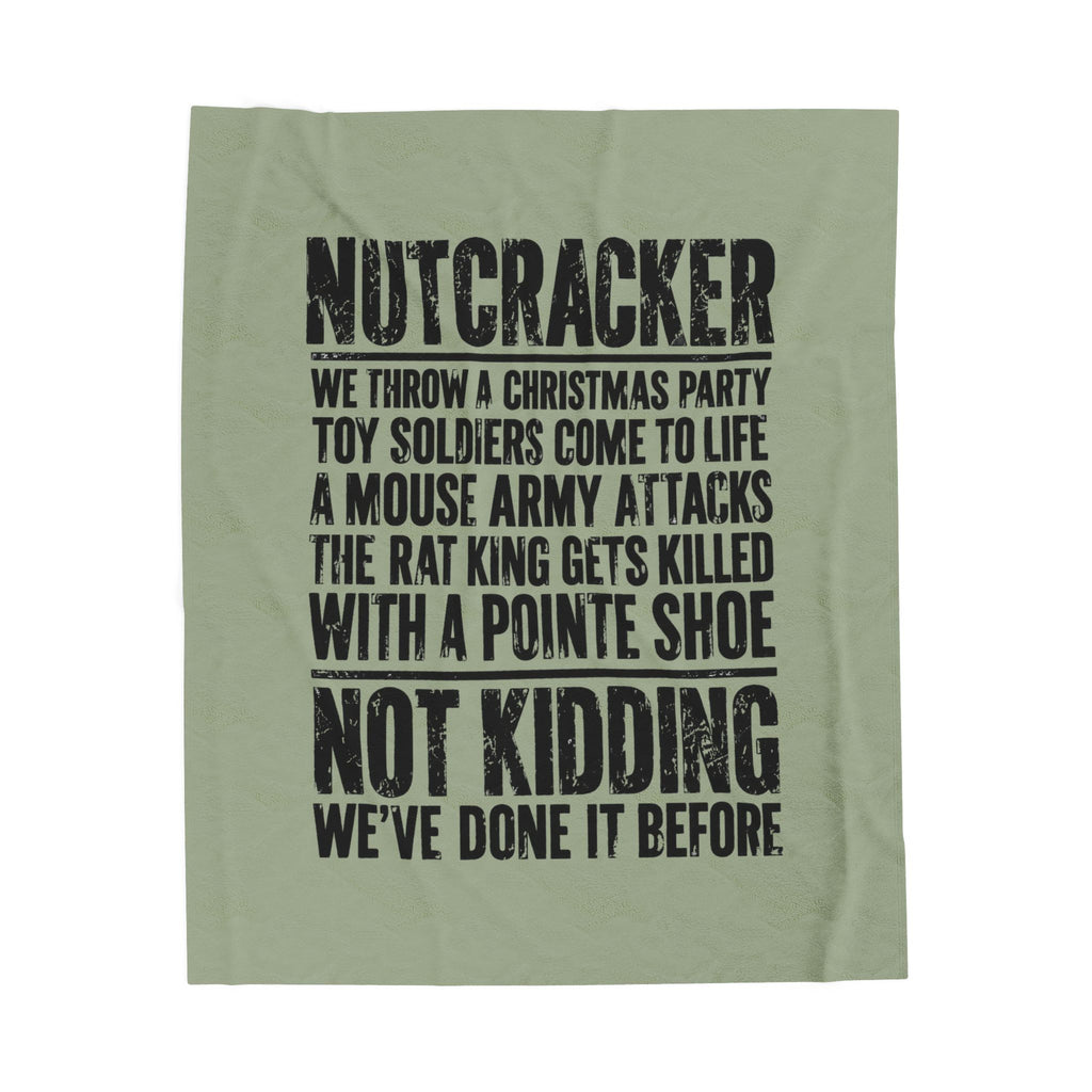An olive green fabric item, likely a towel or blanket, featuring a black distressed text print about a Christmas toy soldier prank.