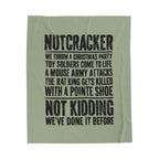 An olive green fabric item, likely a towel or blanket, featuring a black distressed text print about a Christmas toy soldier prank.