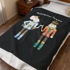 Black blanket with Nutcracker-themed design on a bed
