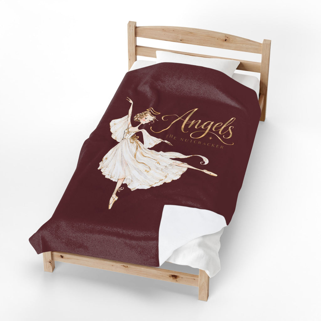 A single wooden bed frame with a burgundy blanket featuring a white ballerina illustration and the words 'Angels Are Coming Up' in gold, shown on a clean white background.