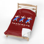 A red bedding set on a wooden toddler bed, featuring a graphic of three cartoon rats in blue and pink costumes with the text 'TEAM RATS The Nutacker'.