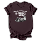 Brown t-shirt with graphic of chicken tenders and a drink, text 'Another Beautiful Day to Spend $18 on Chicken Tenders' on a white background.