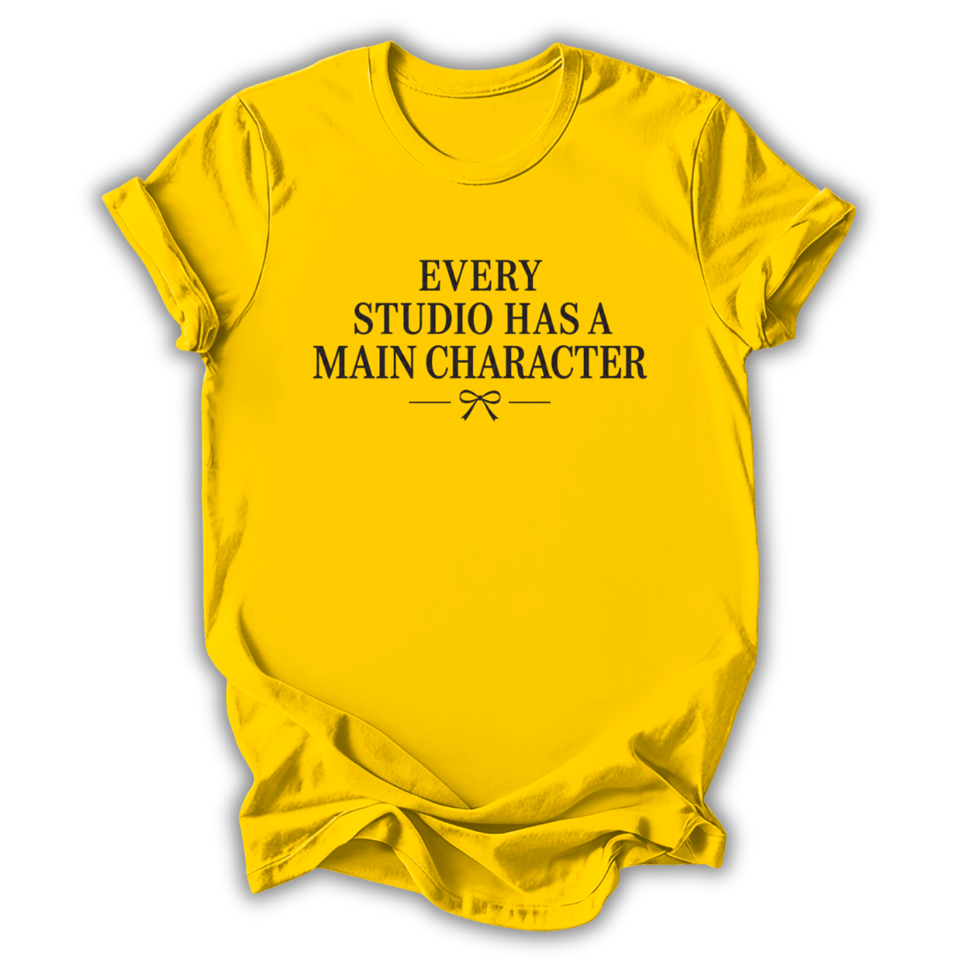 Yellow t-shirt with black text 'Every Studio Has a Main Character' on a white background