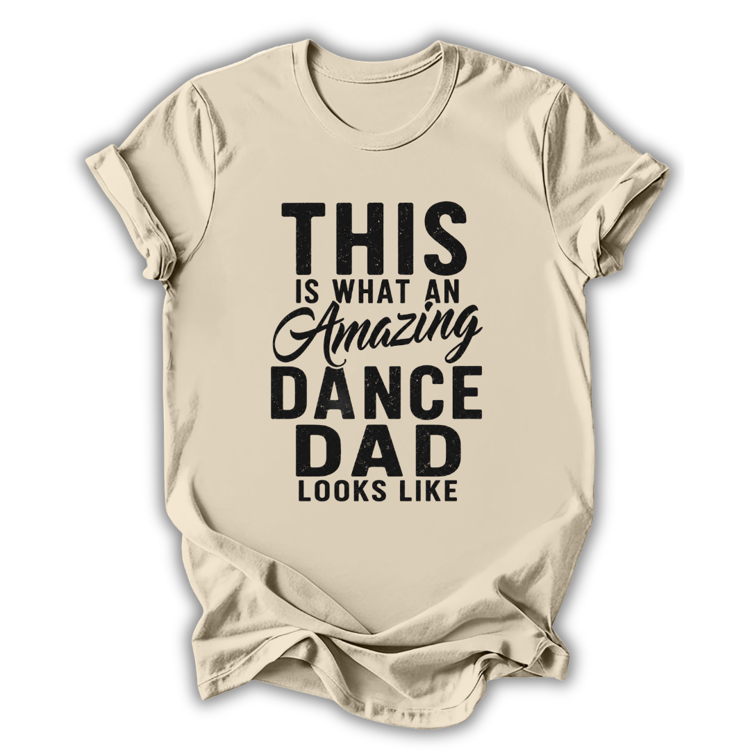 Beige t-shirt with black text 'This is what an amazing dance dad looks like' on a white background