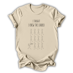 Beige t-shirt with text and stick figure graphic on a white background