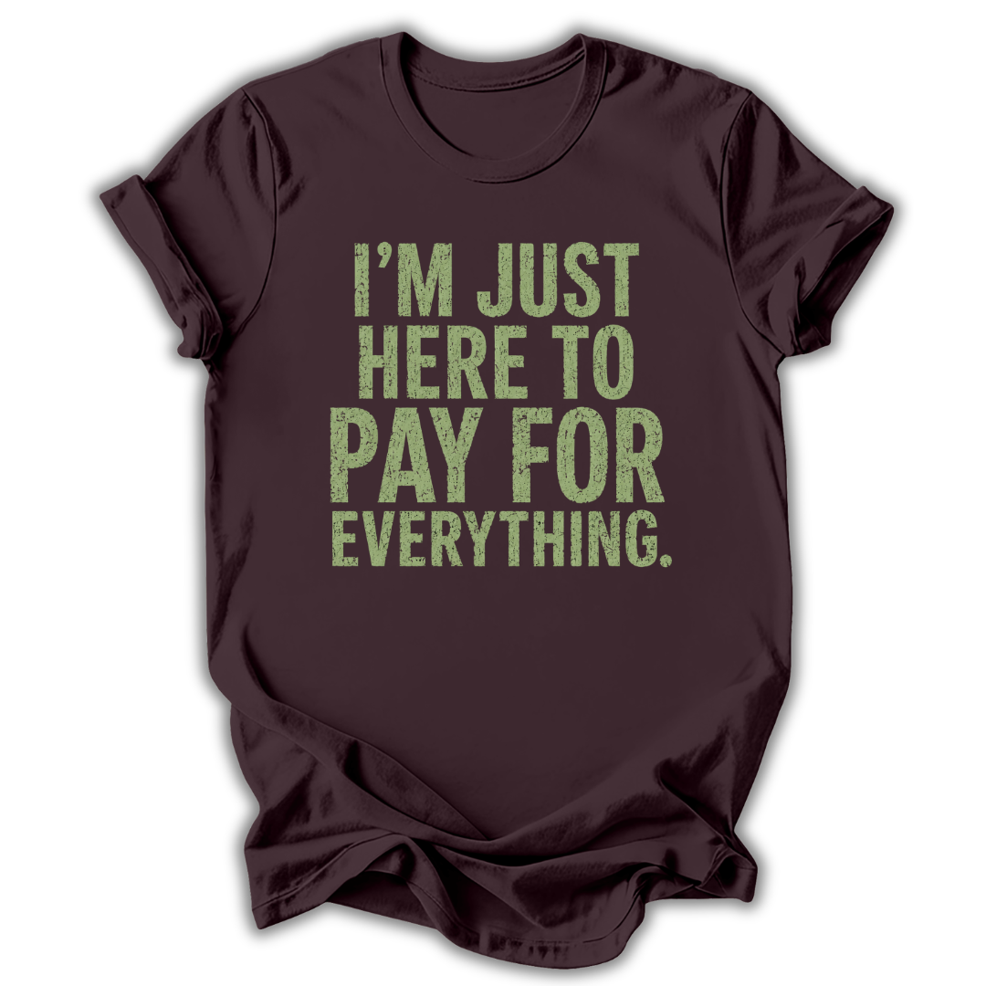 Brown t-shirt with green text 'I'm just here to pay for everything' on a white background
