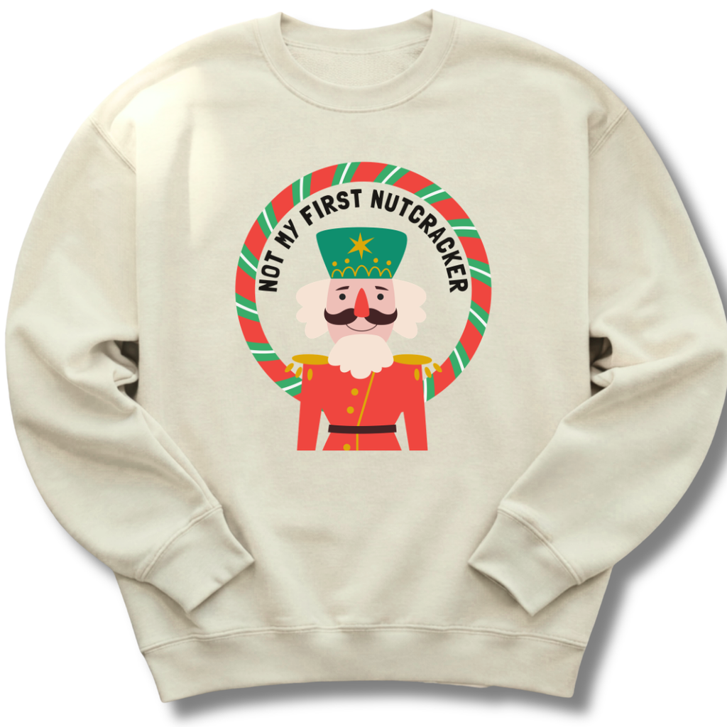 Beige sweatshirt with a cartoon nutcracker design and text on a white background