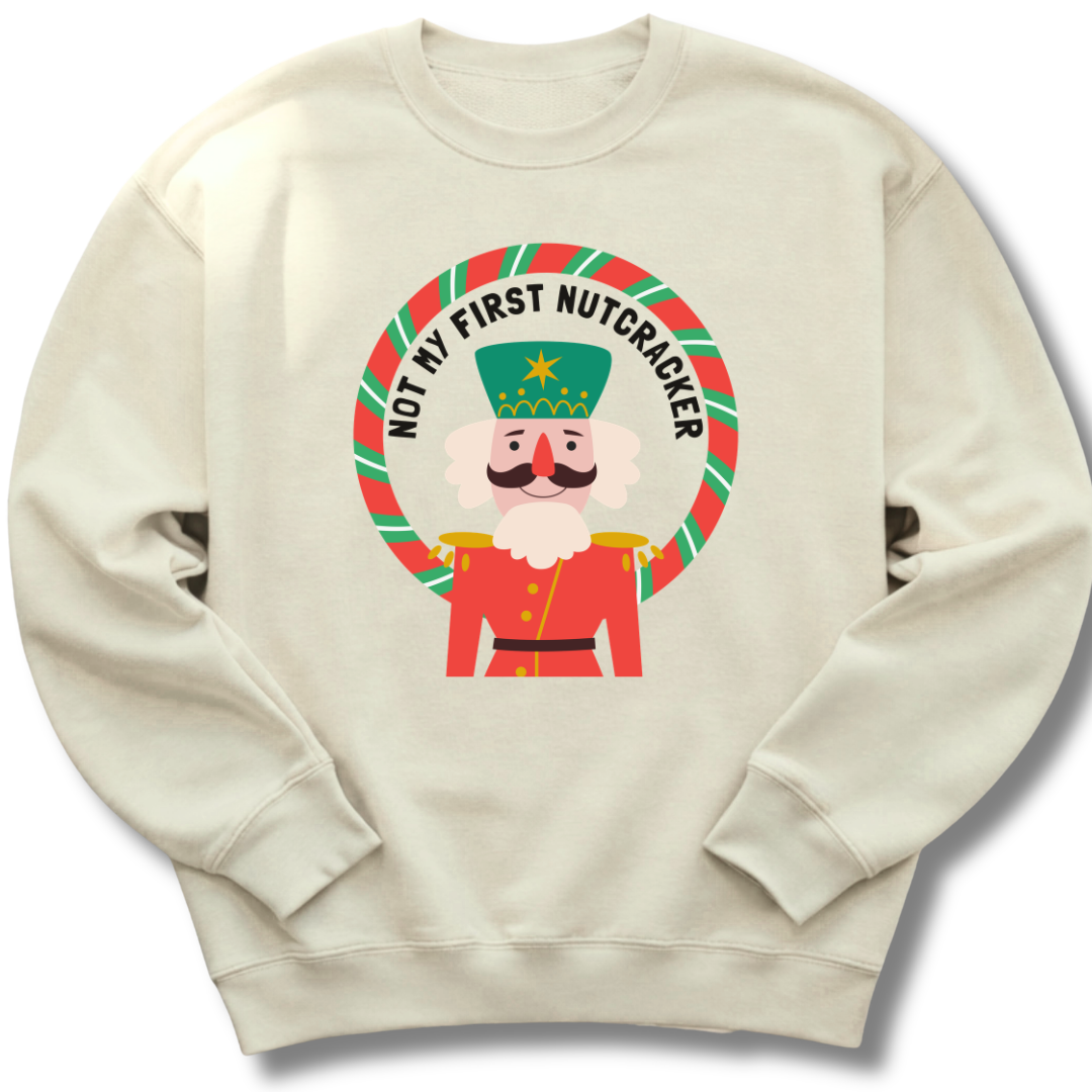 Beige sweatshirt with a cartoon nutcracker design and text on a white background