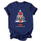 A navy blue short-sleeve t-shirt with a Christmas-themed graphic of a nutcracker standing in front of a white sketched Christmas tree, with the text 'IT'S NUTCRACKER SEASON!' printed below.