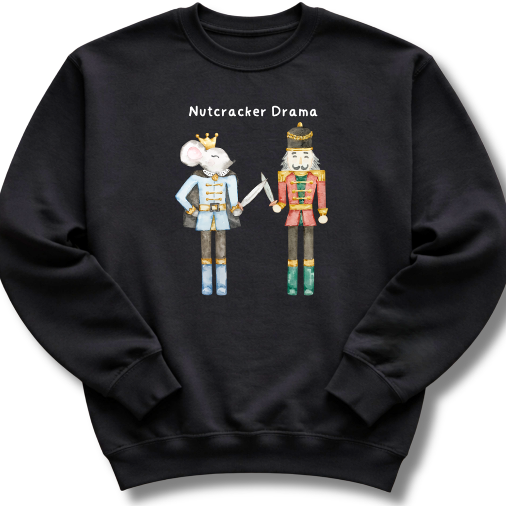 A black crewneck sweatshirt featuring a graphic of a nutcracker mouse in a light blue uniform and a traditional nutcracker in a red and gold uniform, with the text 'Nutcracker Drama' above them.