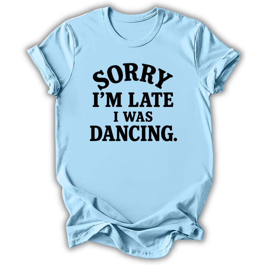 A light blue short-sleeve t-shirt with the text 'SORRY I'M LATE I WAS DANCING.' printed in black across the chest, shown on a plain white background.