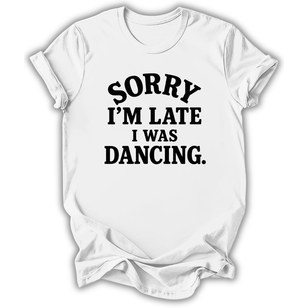 A white short-sleeve crewneck t-shirt with the phrase 'SORRY I'M LATE I WAS DANCING.' printed in black across the chest, shown on a plain white background.