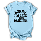 A light blue short-sleeve t-shirt with the text 'SORRY I'M LATE I WAS DANCING.' printed in black across the chest, shown on a plain white background.
