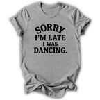 A light gray heather crewneck t-shirt with black printed text reading 'SORRY I'M LATE I WAS DANCING.' on the front, shown against a plain white background.