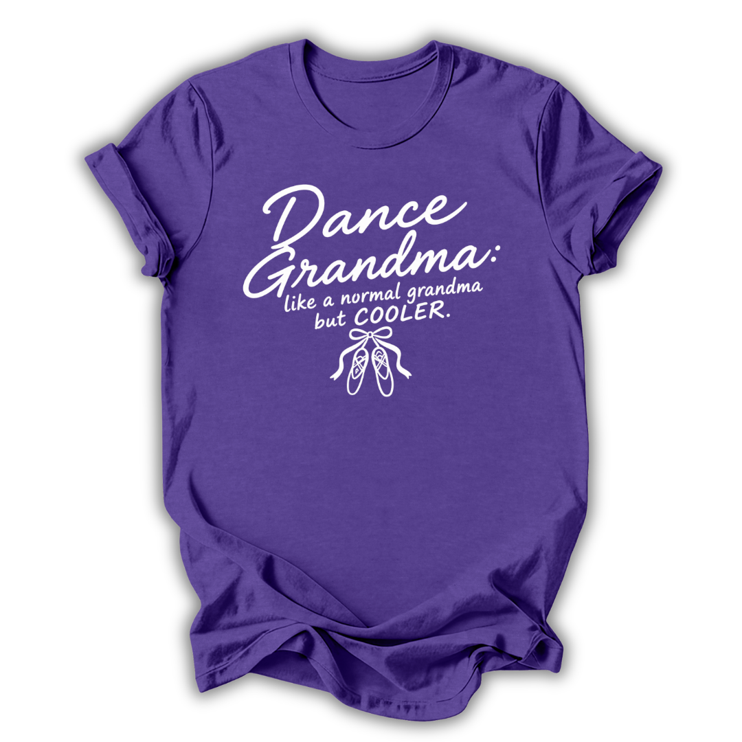 A purple short-sleeve crewneck t-shirt with a white graphic print that reads 'Dance Grandma: like a normal grandma but COOLER.' above a small ballet shoe illustration, shown on a plain white background.