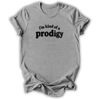A light gray heather crewneck t-shirt with the phrase 'i'm kind of a prodigy' printed in black across the chest, displayed on a clean white background.