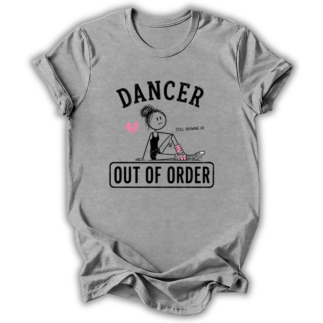A heather gray short-sleeve t-shirt with a graphic print on the front. The print features the word 'DANCER' in arched black letters above a cartoon illustration of a dancer sitting with a broken heart and pink socks, and the phrase 'OUT OF ORDER' inside a black rectangular box.