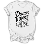 A white short-sleeve crewneck t-shirt with a black graphic print that reads 'Dance Runs This House.' accompanied by a small ballet shoe illustration and a tiny house graphic, shown on a plain white background.
