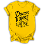 A bright yellow short-sleeve t-shirt with a black graphic print that reads 'Dance Runs This House.' accompanied by a ballet shoe illustration, shown on a plain white background.