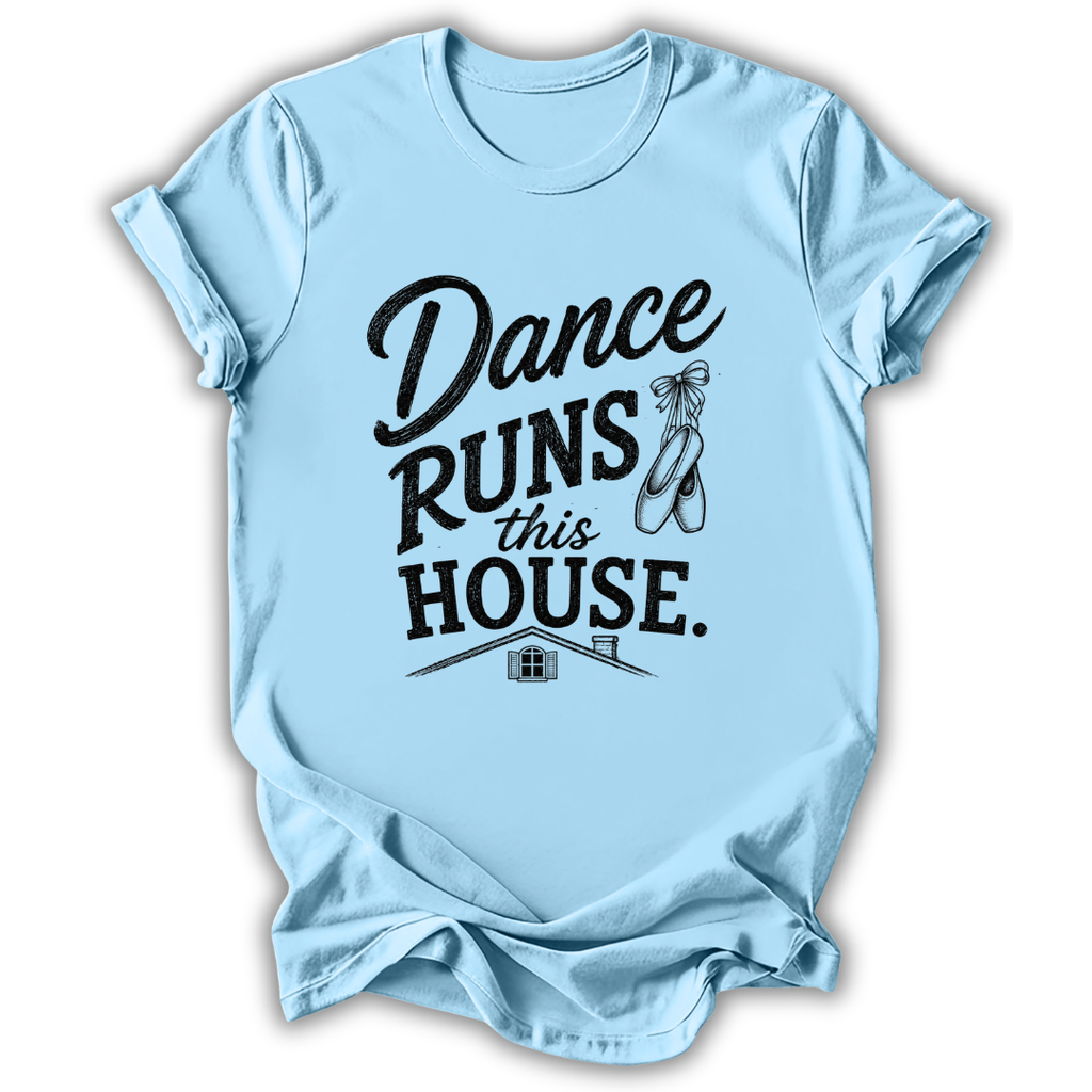 A light blue short-sleeve t-shirt with a black graphic print that reads 'Dance Runs This House.' accompanied by ballet shoes and a small house illustration, shown on a white background.