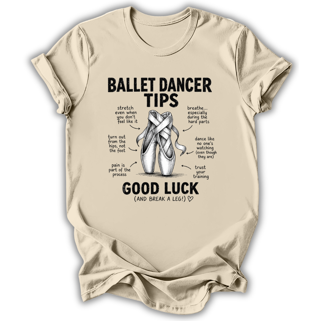 A beige crewneck t-shirt with a black graphic print titled 'Ballet Dancer Tips' featuring an illustration of ballet pointe shoes and humorous tips with handwritten-style text, shown on a plain white background.