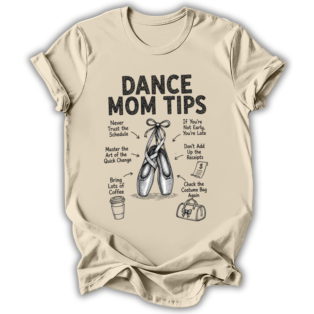 A beige short-sleeve crewneck t-shirt with a black graphic print titled 'DANCE MOM TIPS' featuring illustrations of ballet slippers and dance-related advice, shown on a plain white background.
