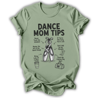 A sage green short-sleeve t-shirt with a black graphic print that reads 'DANCE MOM TIPS' and features illustrations of ballet shoes, a coffee cup, and a shopping bag with humorous dance-related phrases.
