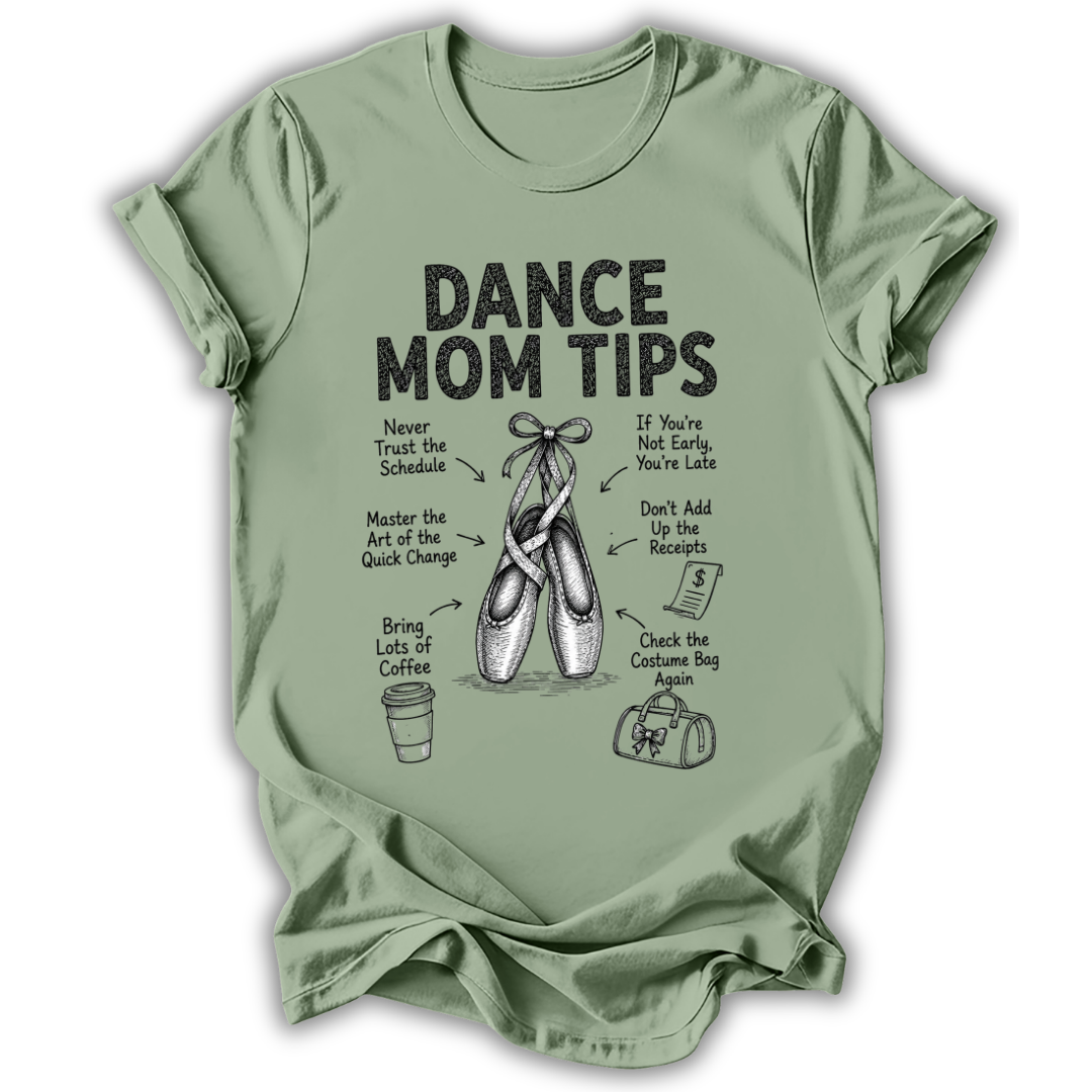 A sage green short-sleeve t-shirt with a black graphic print that reads 'DANCE MOM TIPS' and features illustrations of ballet shoes, a coffee cup, and a shopping bag with humorous dance-related phrases.