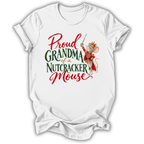 A white short-sleeve crewneck t-shirt with a graphic print on the front. The graphic features the text 'Proud GRANDMA of a NUTCRACKER Mouse' in red and green lettering, accompanied by an illustration of a nutcracker mouse wearing a red and gold costume and holding a sword.