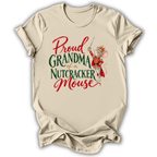 A beige short-sleeve t-shirt with a graphic print that reads 'Proud GRANDMA of a Nutcracker Mouse' in red and green lettering, featuring an illustration of a nutcracker mouse in a red and gold costume.