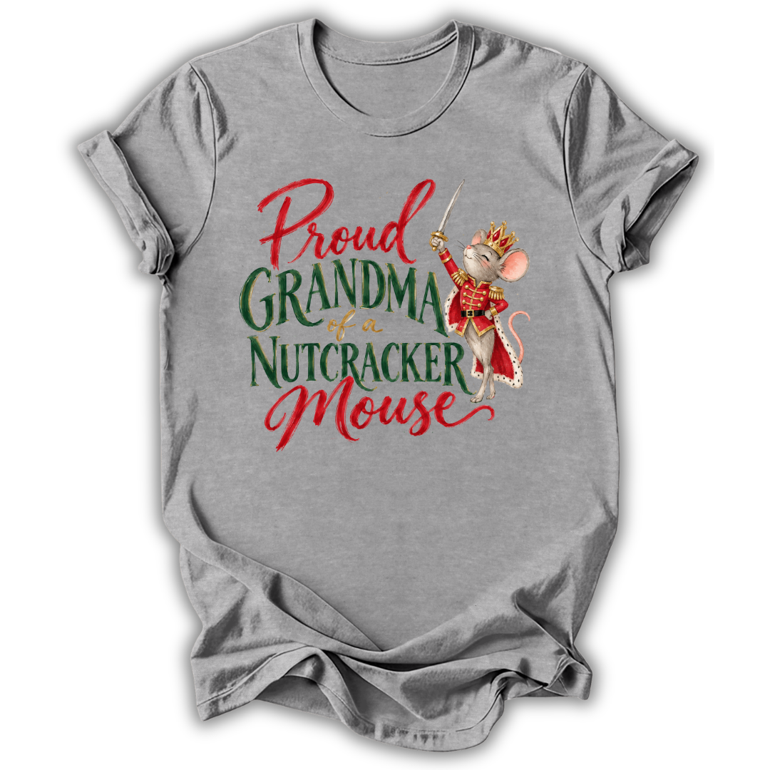 A heather gray short-sleeve t-shirt with a graphic print that reads 'Proud GRANDMA of a NUTCRACKER Mouse' in red and green lettering, featuring an illustration of a nutcracker mouse in a red and gold costume.