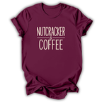 A maroon short-sleeve crewneck t-shirt with the words 'NUTCRACKER & COFFEE' printed in a cream-colored serif font on the chest, displayed against a clean white background.
