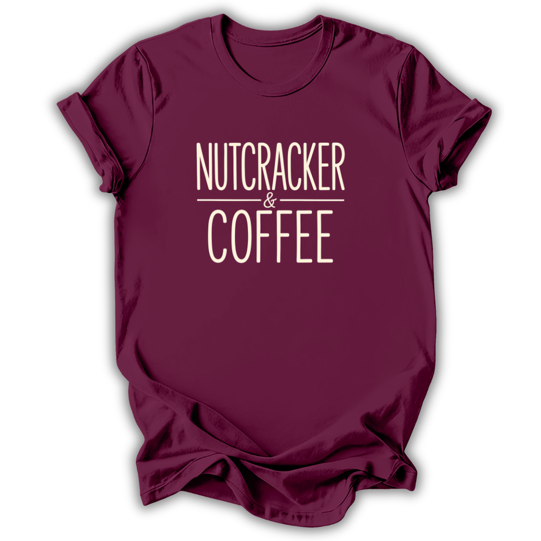 A maroon short-sleeve crewneck t-shirt with the words 'NUTCRACKER & COFFEE' printed in a cream-colored serif font on the chest, displayed against a clean white background.
