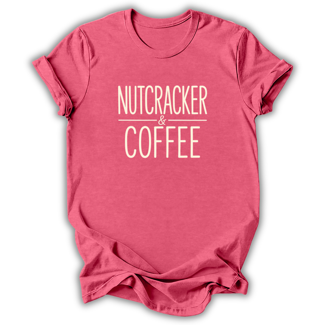 A heather pink short-sleeve t-shirt with the text 'NUTCRACKER & COFFEE' printed in a light pinkish-beige font on the chest, displayed on a clean white background.