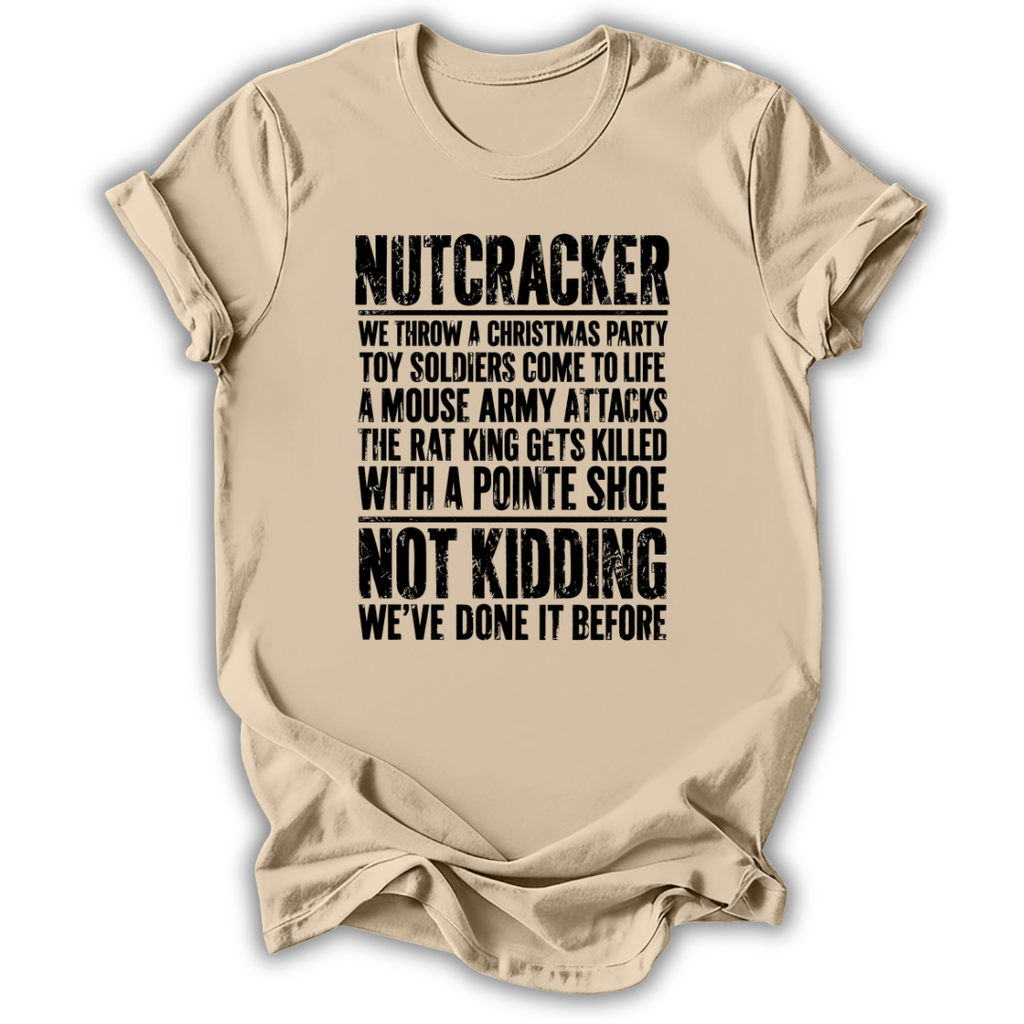 A beige crewneck t-shirt with a humorous, distressed black graphic text print about a nutcracker and Christmas toy soldiers, displayed on a clean white background.