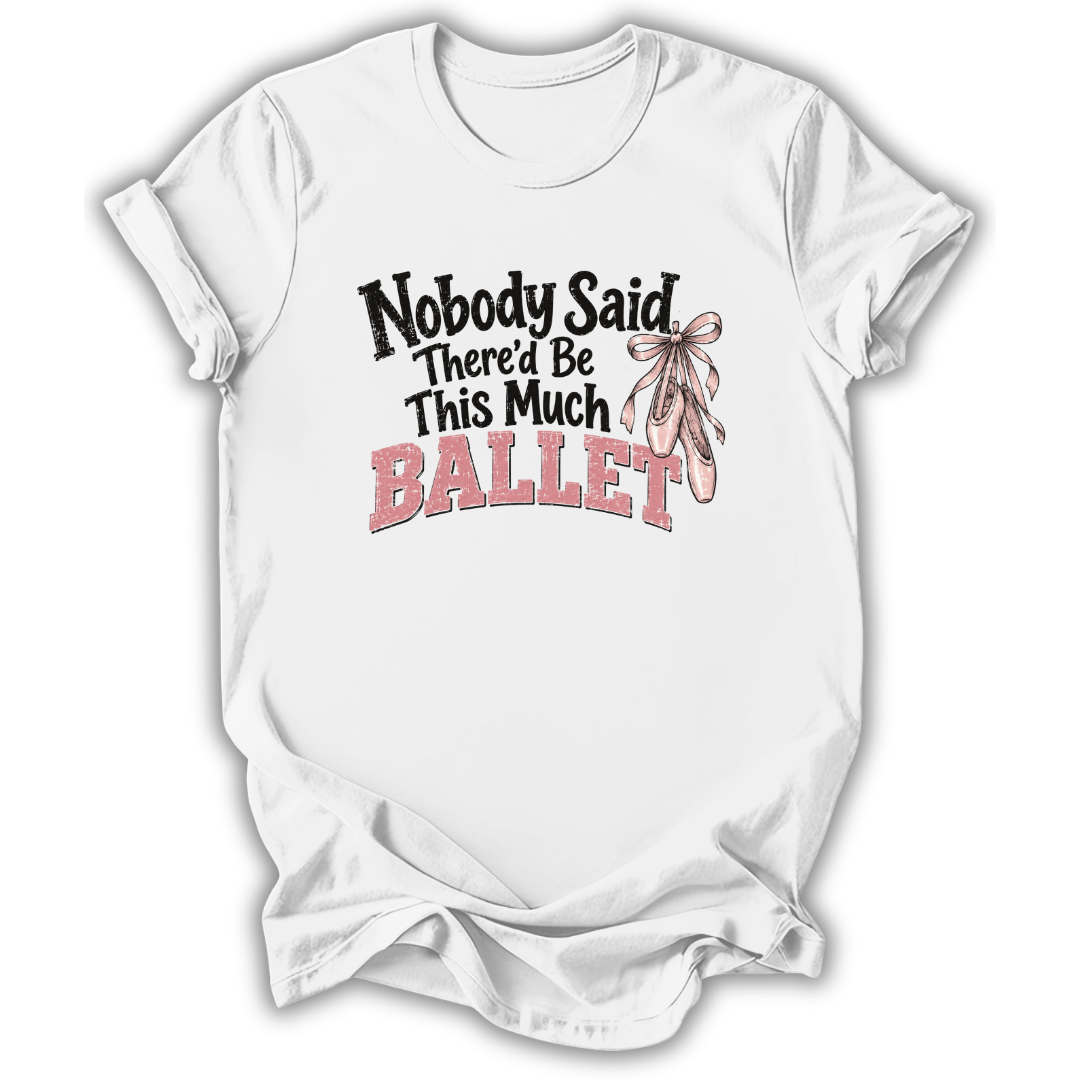 A white short-sleeve crewneck t-shirt with a graphic print on the front that reads 'Nobody Said There'd Be This Much BALLET' in black and pink lettering, accompanied by an illustration of a pink ballet ribbon. The t-shirt is shown against a plain white background.