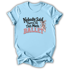A light blue short-sleeve t-shirt with a graphic on the front that reads 'Nobody Said There'd Be This Much BALLET' in black and pink lettering, accompanied by an illustration of pink ballet slippers with a ribbon. The t-shirt is shown against a plain white background with a soft drop shadow.