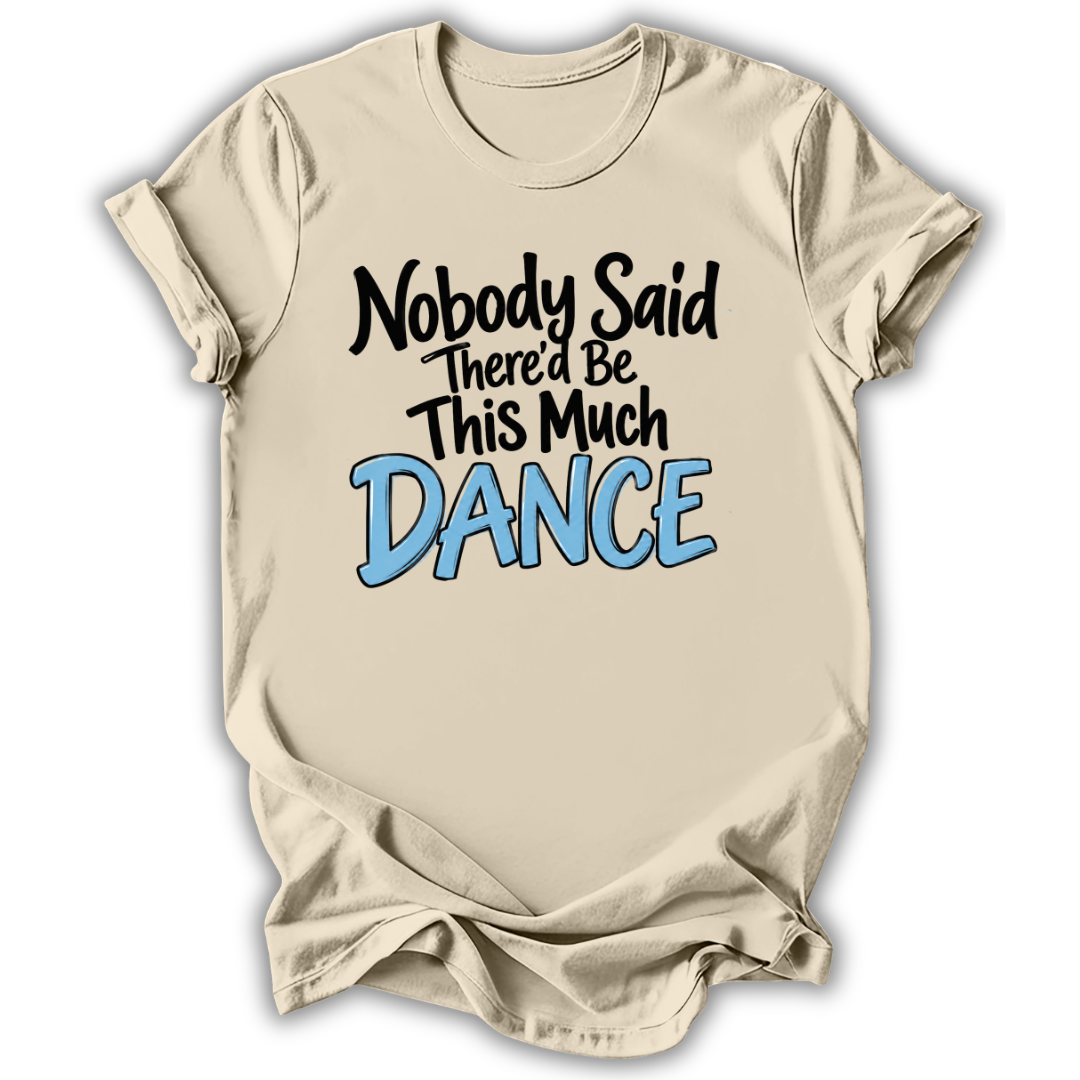 A beige short-sleeve t-shirt with a graphic text print reading 'Nobody Said There'd Be This Much DANCE' in black and light blue lettering, displayed against a white background.