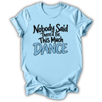 A light blue short-sleeve t-shirt with a graphic text print reading 'Nobody Said There'd Be This Much DANCE' in black and light blue lettering, displayed on a white background with a drop shadow.