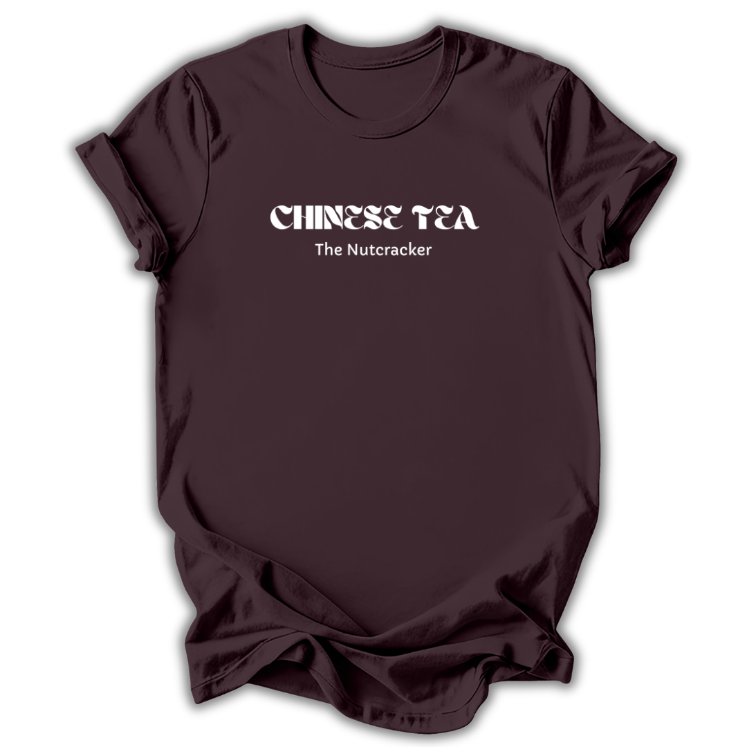 Brown short-sleeve t-shirt with white text reading 'CHINESE TEA' and 'The Nutcracker' printed on the chest, displayed against a clean white background.