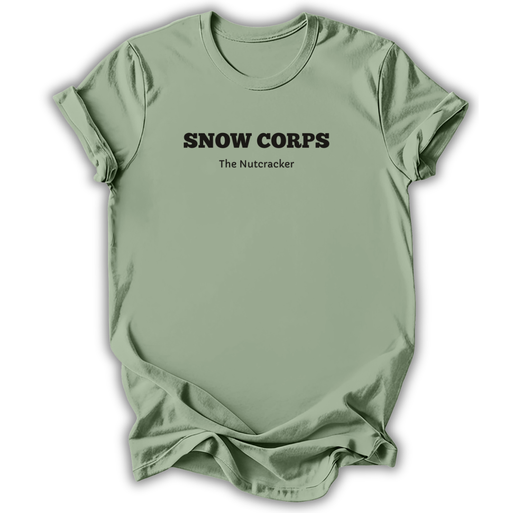 A sage green short-sleeve t-shirt with black printed text reading 'SNOW CORPS' and 'The Nutcracker' underneath, displayed flat against a white background.