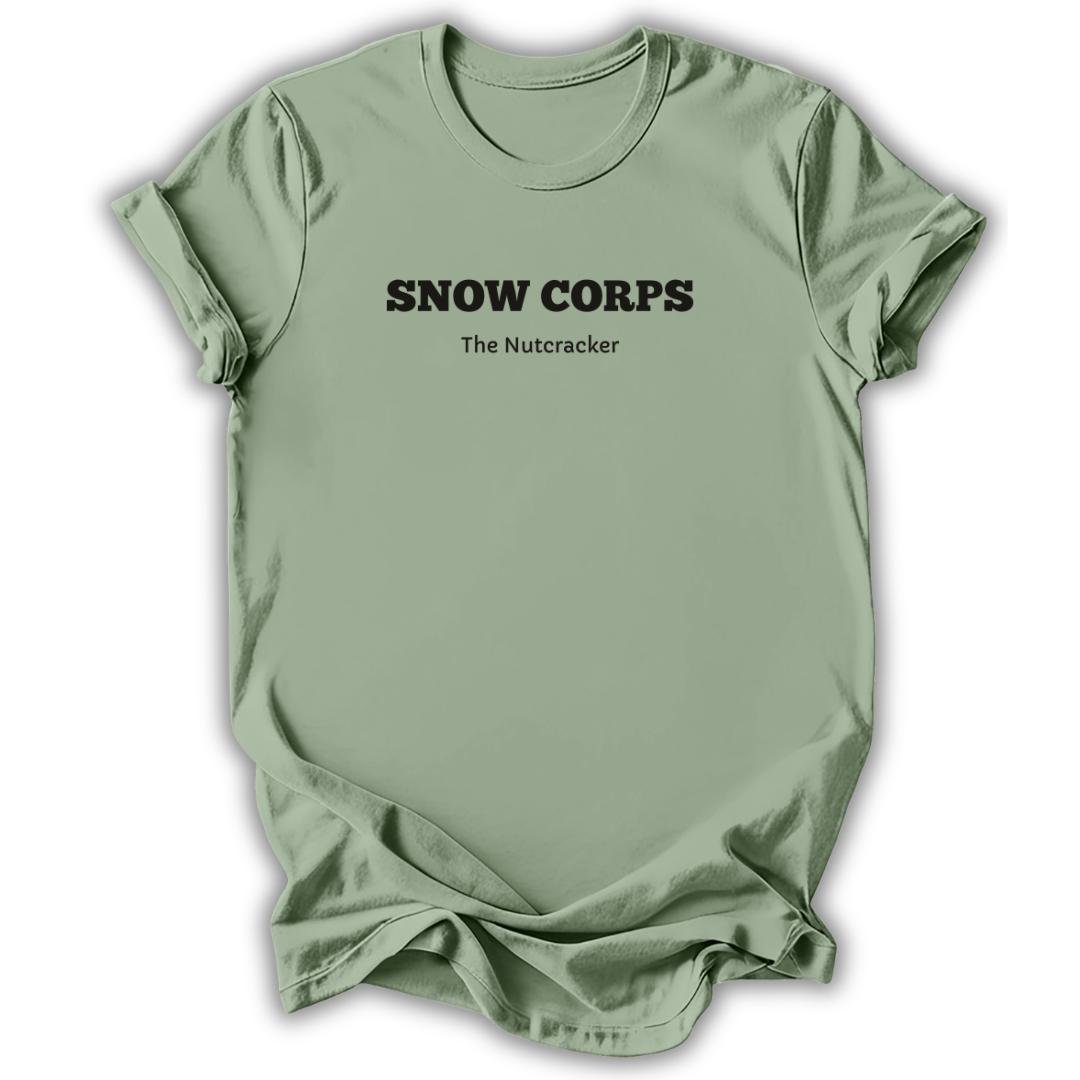 A sage green short-sleeve t-shirt with black printed text reading 'SNOW CORPS' and 'The Nutcracker' underneath, displayed flat against a white background.