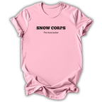 Pink short-sleeve t-shirt with black printed text reading 'SNOW CORPS' and 'The Nutcracker' underneath, displayed flat against a white background.