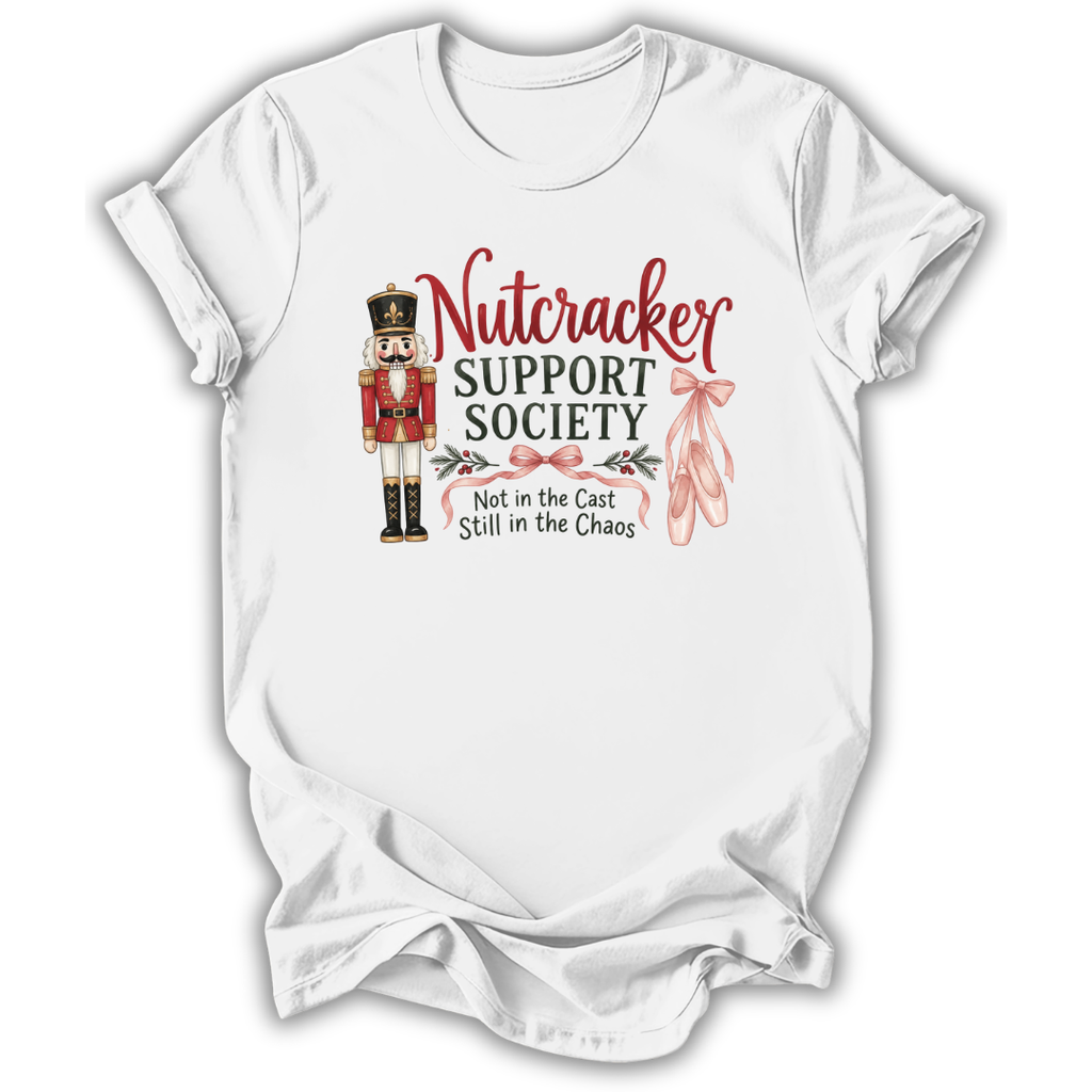 A white short-sleeve crewneck t-shirt with a graphic print on the front. The graphic features a nutcracker soldier, pink ballet slippers, and the text 'Nutcracker SUPPORT SOCIETY Not in the Cast Still in the Chaos'.
