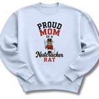 A light blue crewneck sweatshirt with a graphic print that reads 'PROUD MOM OF A Nutcracker RAT' in black and red lettering, featuring a cartoon nutcracker rat holding a sword.