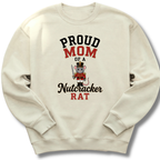 An off-white crewneck sweatshirt featuring a graphic print that reads 'PROUD MOM OF A Nutcracker RAT' with an illustration of a nutcracker mouse.