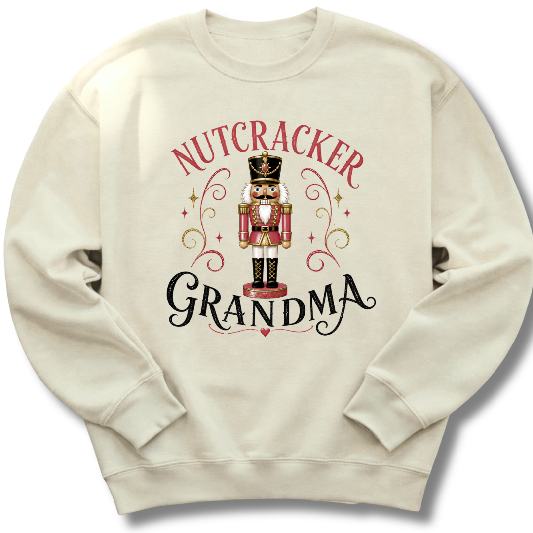 An off-white crewneck sweatshirt featuring a festive graphic of a nutcracker soldier with the words 'NUTCRACKER GRANDMA' in red and black lettering.