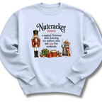 A light blue crewneck sweatshirt featuring a humorous graphic definition of 'Nutcracker' as a noun, illustrated with a nutcracker soldier and a crowned mouse with gifts.