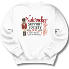 A white crewneck sweatshirt featuring a 'Nutcracker Support Society' graphic on the chest, complete with a nutcracker illustration, red script text, and pink ballet slippers.